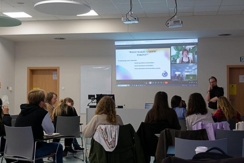 Grupa studentów słucha wykładu i patrzy na wyświetloną prezentację