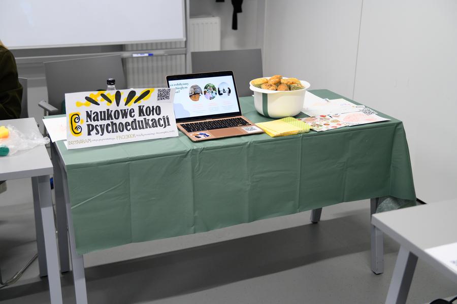 Laptop i duża misa ciastek na stoisku Naukowego Koła Psychoedukacji