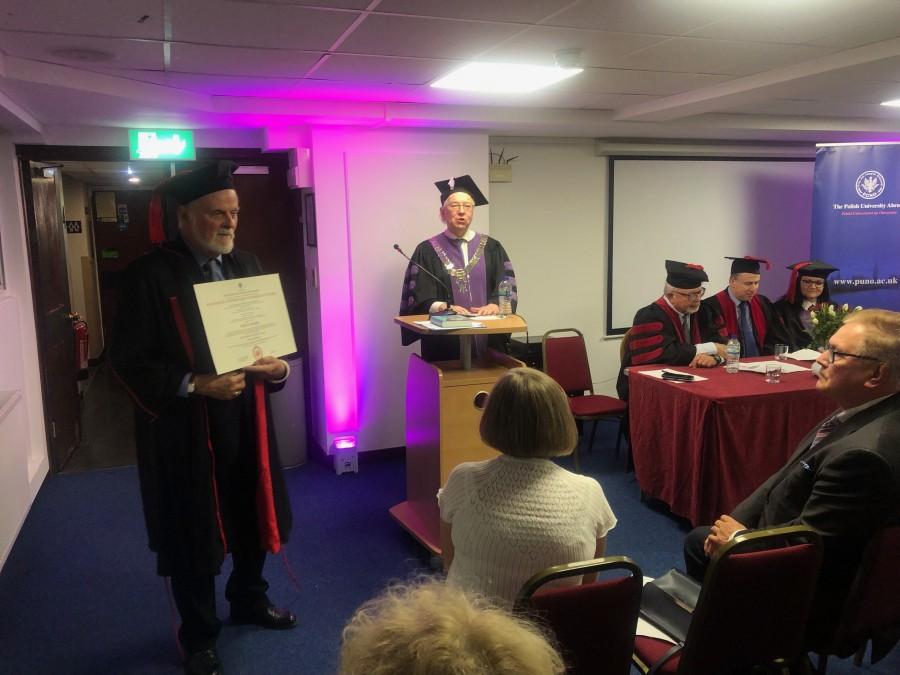 Profesor Boski prezentuje publiczności dyplom doktora honoris causa