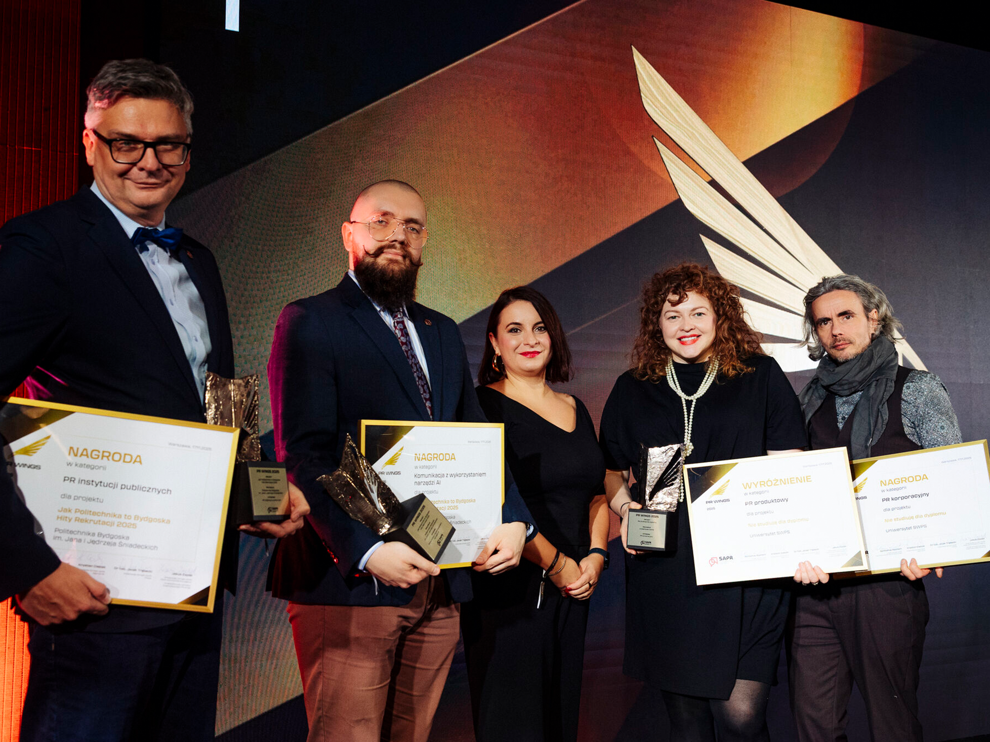 Ewelina Kolendowicz-Ossowska i Łukasz Skorupski z Działu Marketingu Uniwersytetu SWPS podczas odbierania nagrody PR Wings 2025 za kampanię „Nie studiuję dla dyplomu”