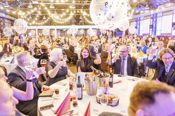Gala Nagrody Stowarzyszenia PRom 2026. Uczestniczki i uczestnicy Gali przy jednym ze stołów bankietowych wznoszą toast kieliszkami wina